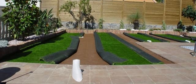 Rollos de césped artificial durante una instalación residencial